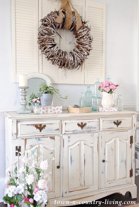 Create a Spring Vignette. shabby chic, painted furniture, distressed furniture, white furniture, buffet, spring decor, spring decorating ideas, vintage bottles