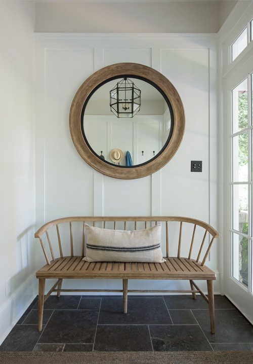 wood bench and round mirror in entryway