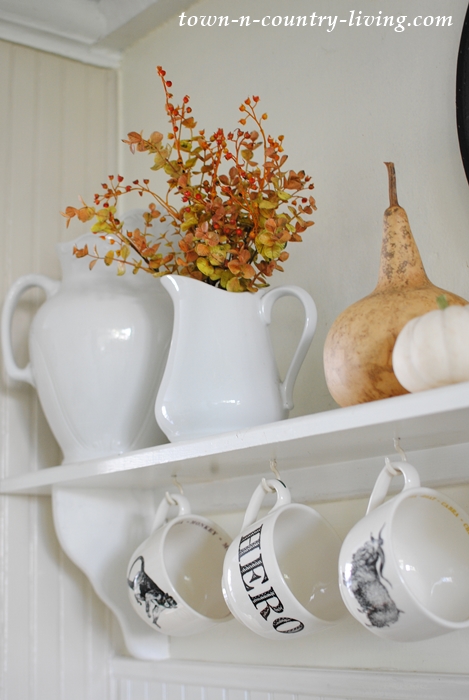 Fall foliage and dried gourds add autumn appeal to a farmhouse kitchen