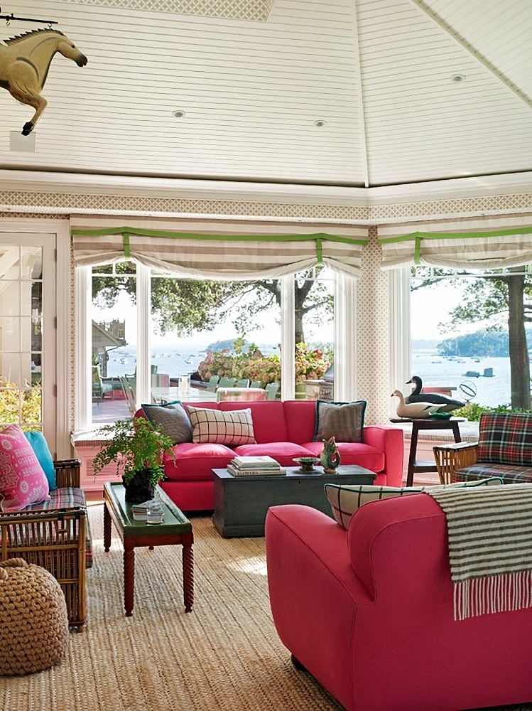 Raspberry couches in waterfront sun room