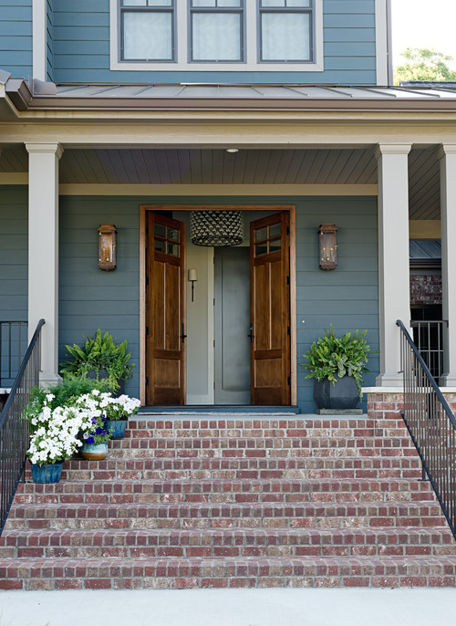 Blue House Entryway with Brick Steps and Porch