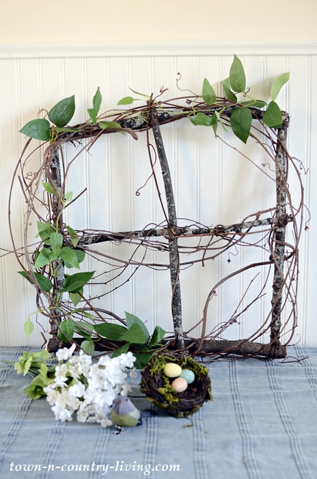 Add greenery to branch and vine spring wreath