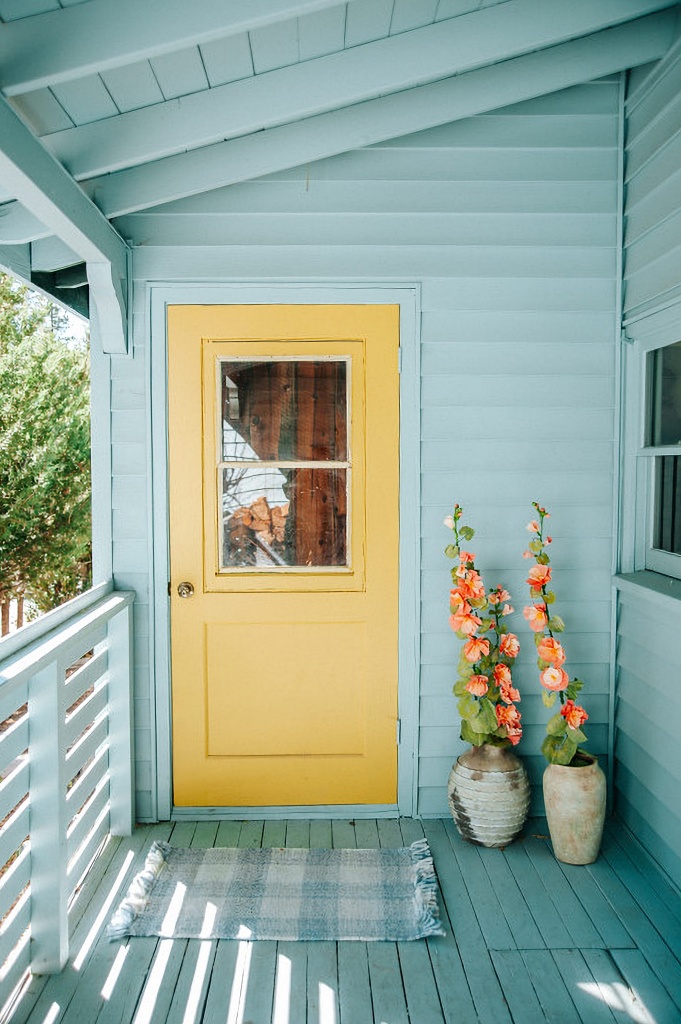 yellow door on aqua house
