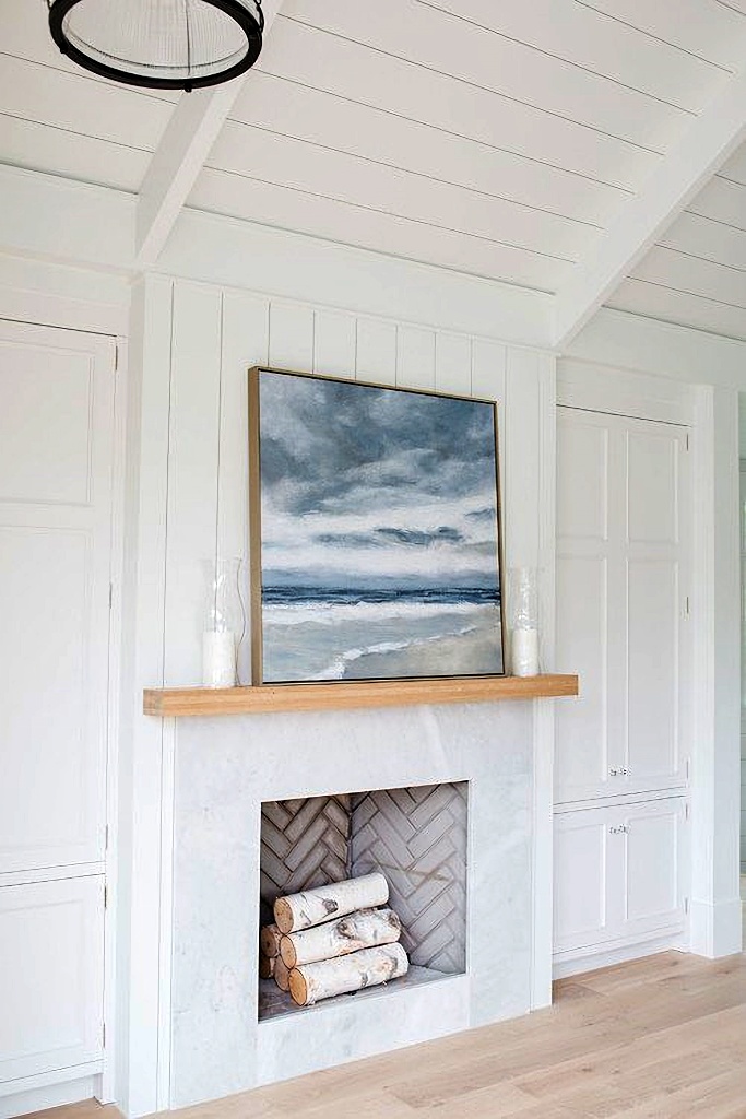 white fireplace with waterscape painting