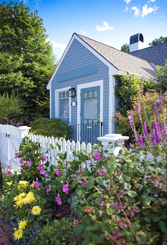 New England garden cottage with white picket fence and messy flowers