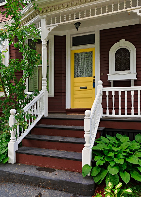 Brown Victorian House with Front Porch and Yellow Front Door