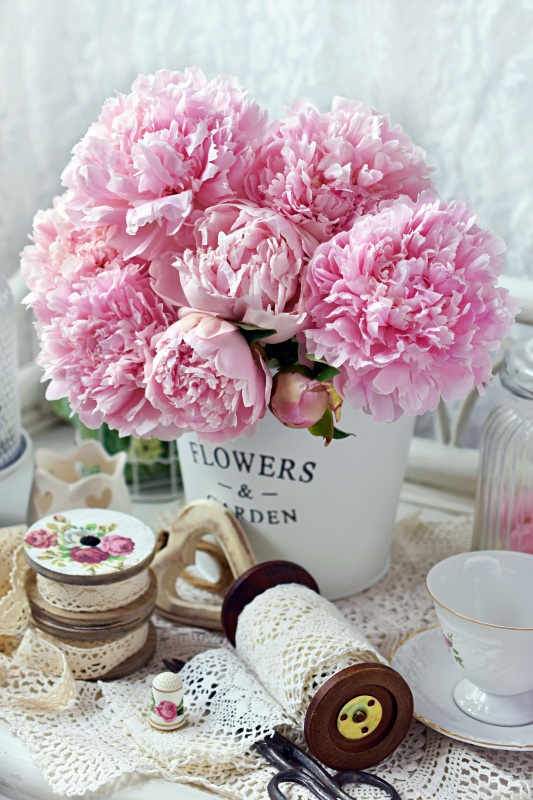 bunch of pink peony flowers in metal bucket in shabby chic style interior