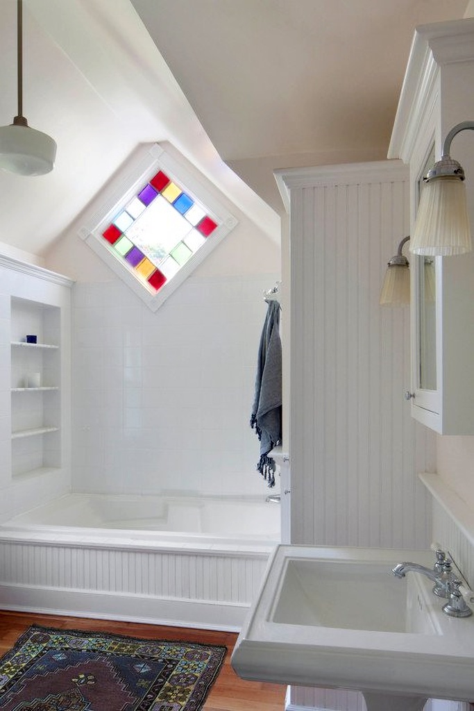Stained glass diamond window in white bathroom