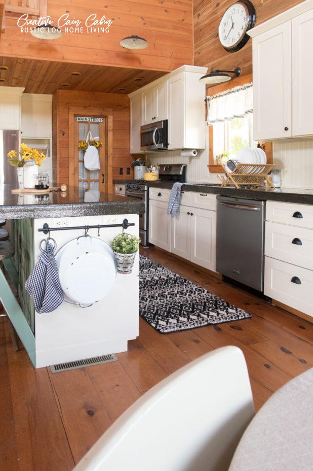 Cabin Style Kitchen with Wood Plank Walls and White Cabinets