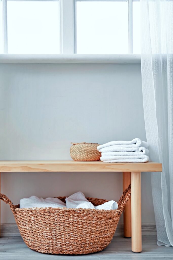 Bench and baskets with towels in bathroom