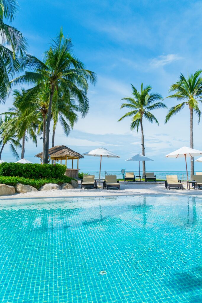 Beautiful tropical beach and sea with umbrella and chair around swimming pool in hotel resort 