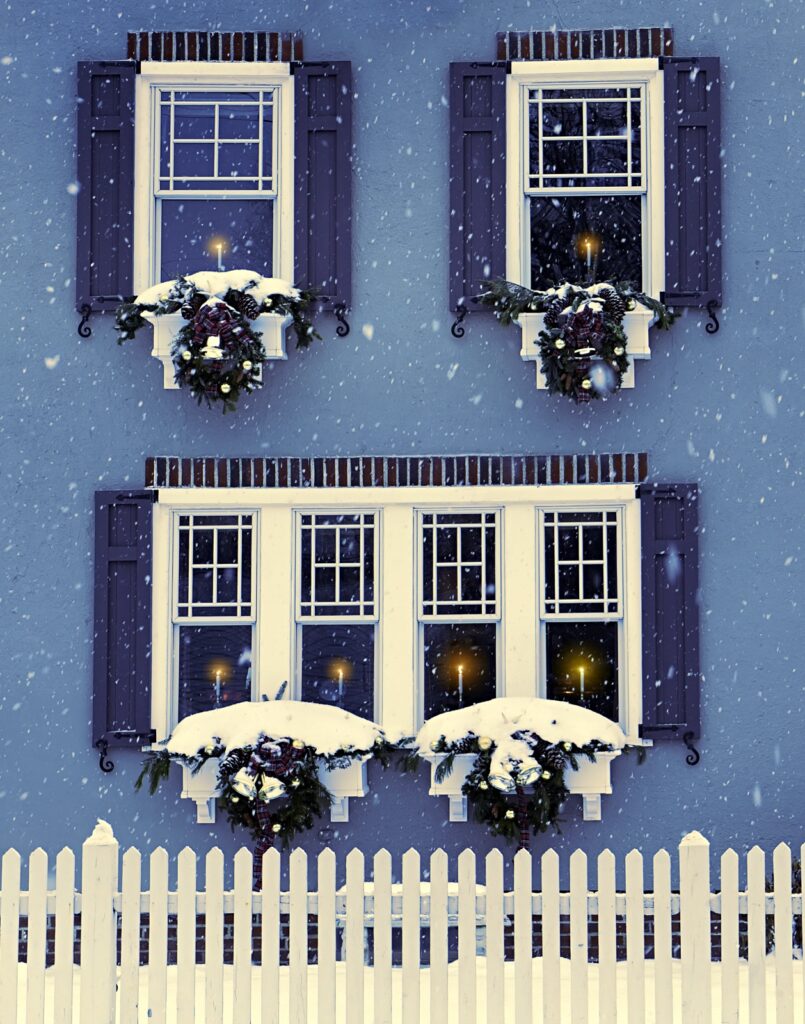 Blue House in Winter with White Picket Fence