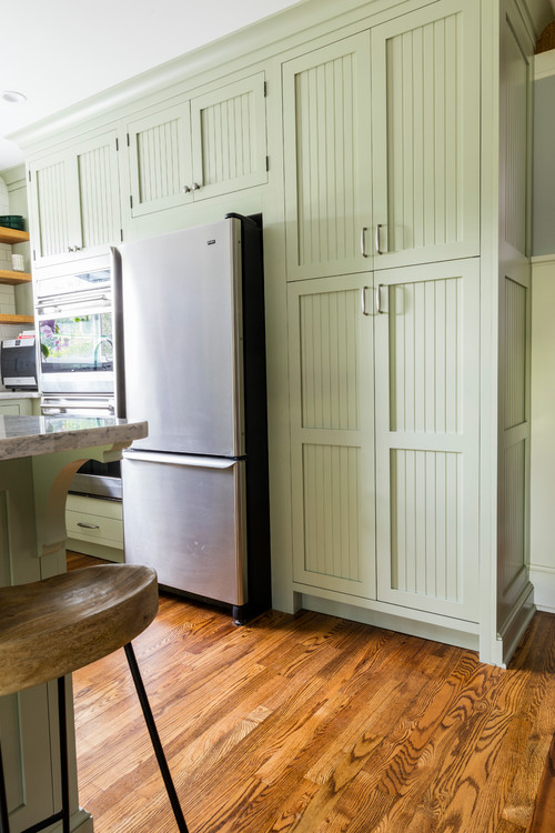 Light green bead board cabinets in classic kitchen