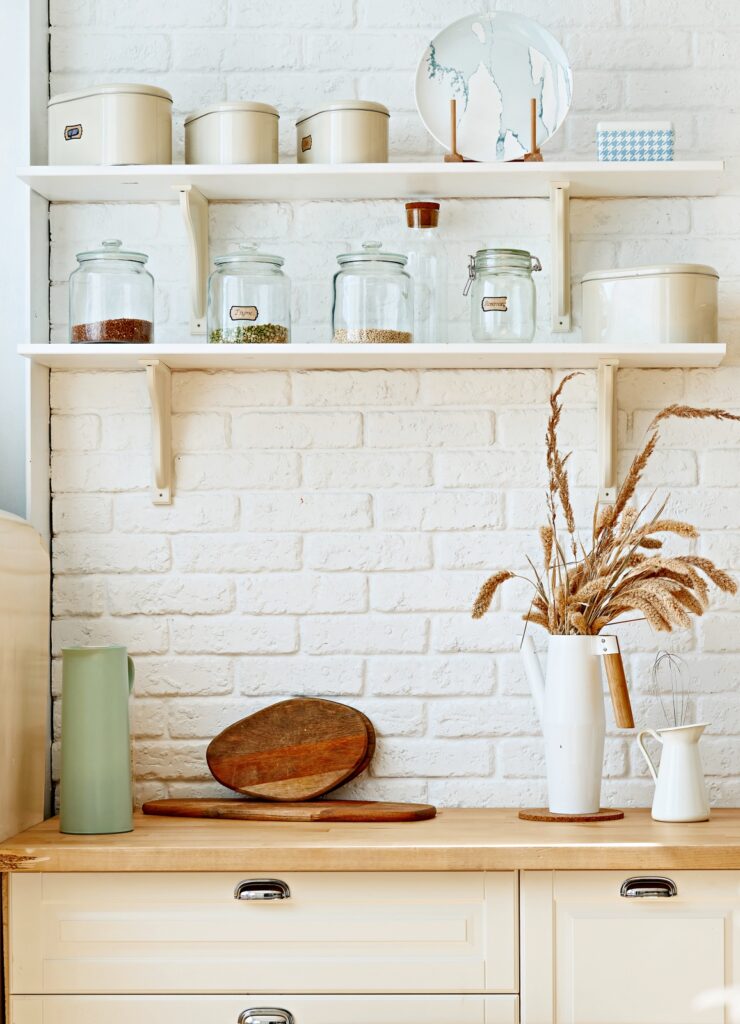 Open shelves in a Scandinavian style kitchen with painted brick wall