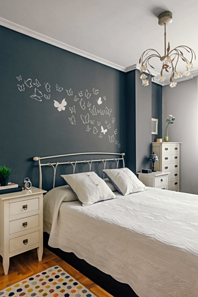 White butterfly mural on gray bedroom wall