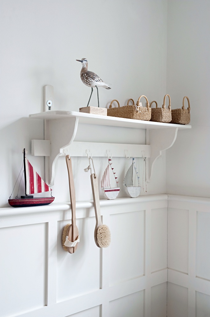 Bird statue and baskets on bathroom shelf