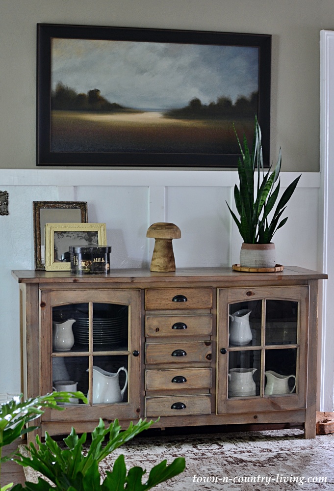 Landscape painting over wooden dining room buffet