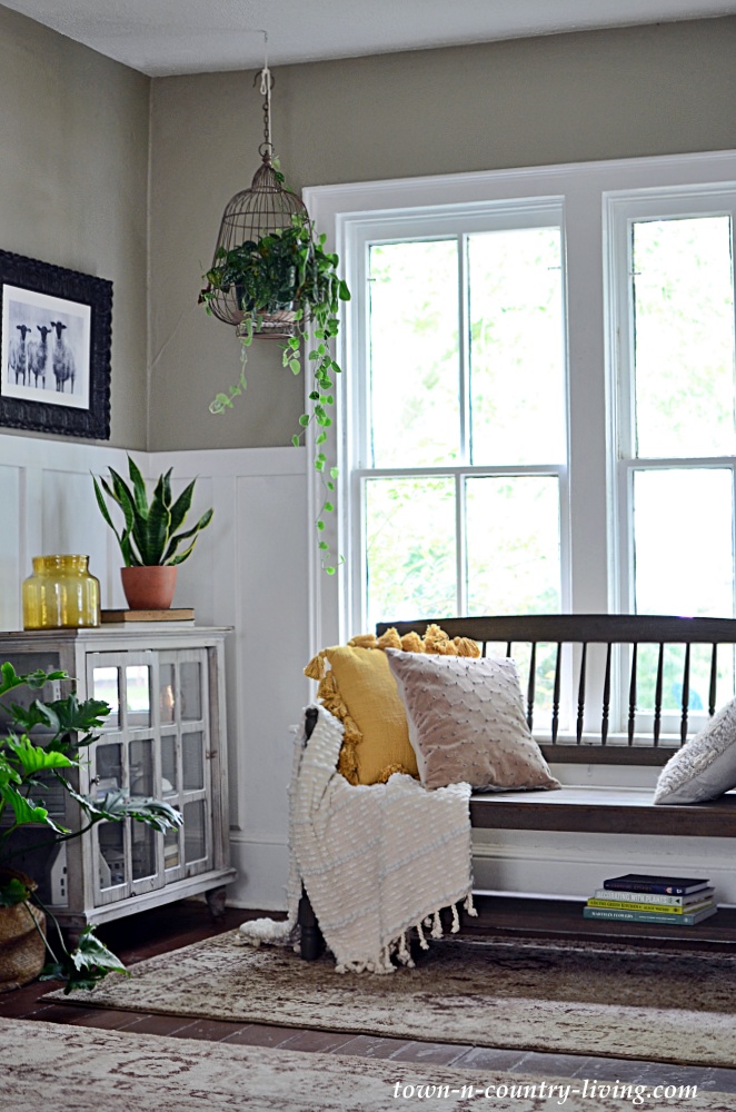 decorate for fall in the entryway with wooden bench and cozy pillows and throw