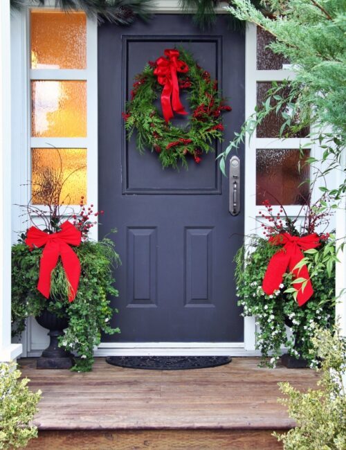 Front door with a Christmas wreath and bows.
