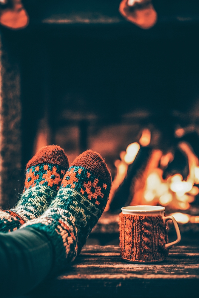 Warm patterned socks by the fireplace - Hygge activities