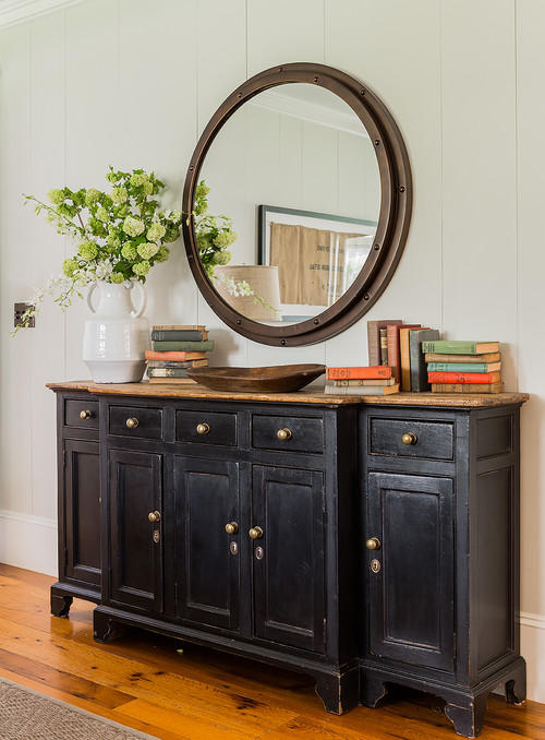 Black bachelor's chest with round mirror in entryway