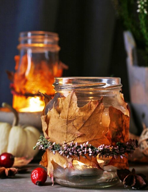 Autumn lantern jars decorated with colorful leaves and heather wreath.