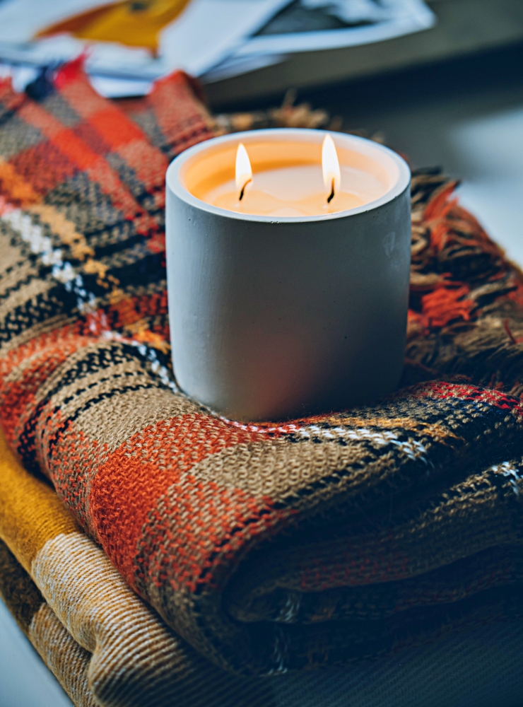 Fall candle with plaid throws - hygge activities to enjoy