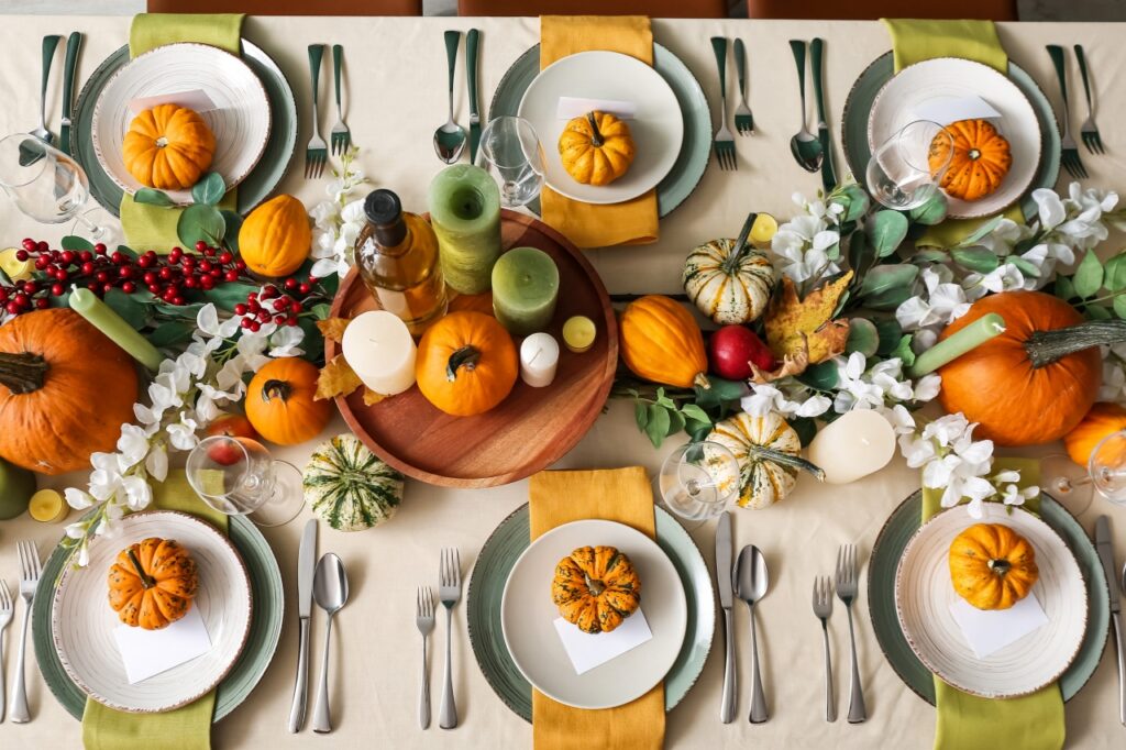 Autumn table setting with fresh pumpkins and flowers