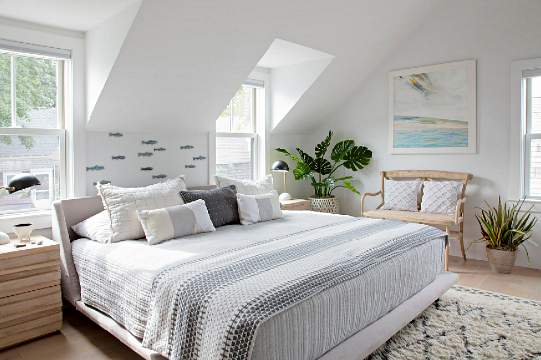 Small white bedroom dressed in beach colors of pale blue and driftwood