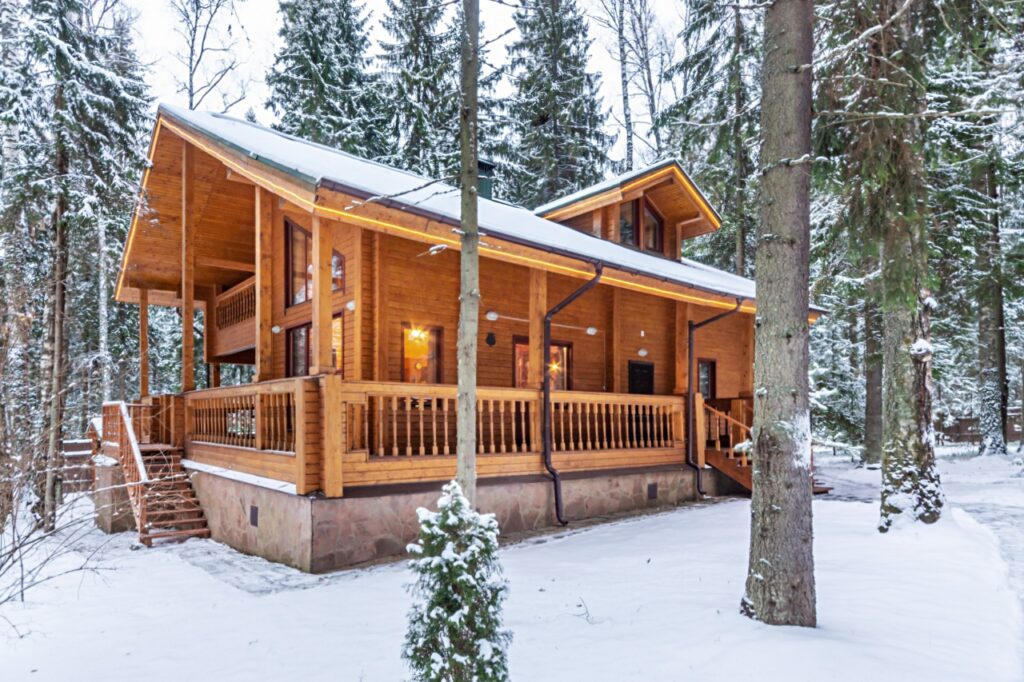 Modern log cabin with large deck in the snow