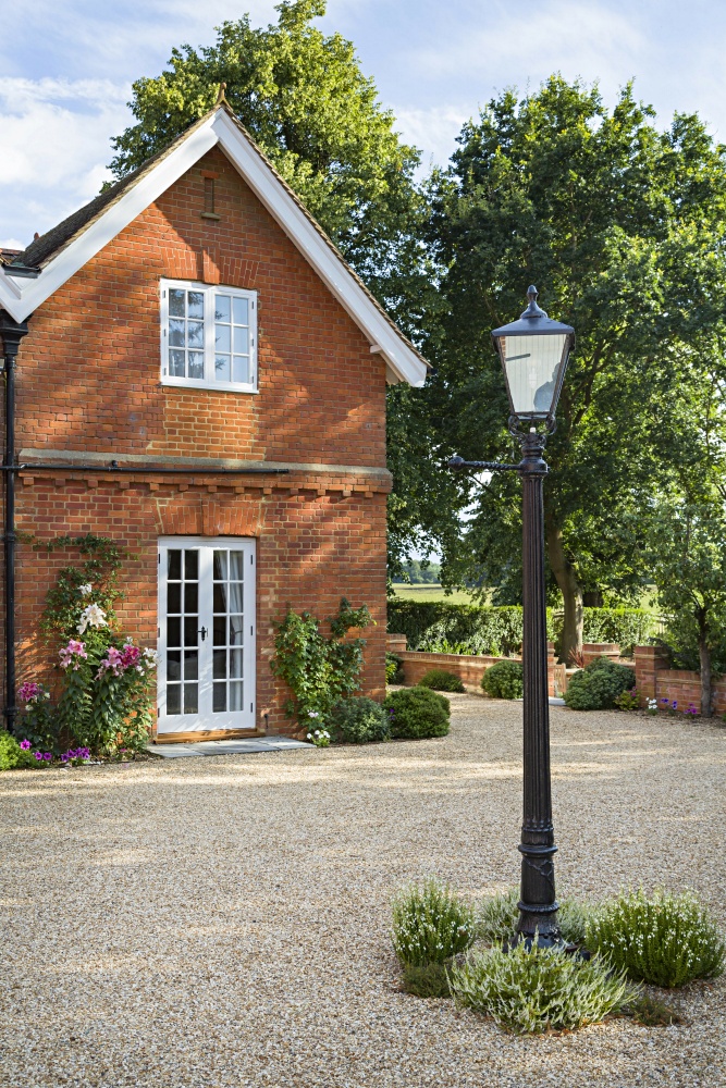 Red brick English cottage with black lamp post