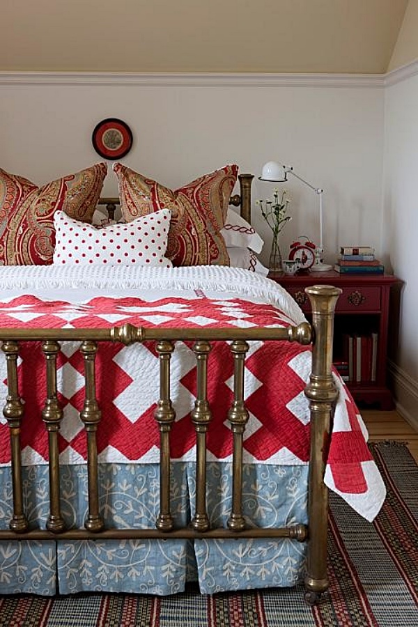 Tradtional bedroom with vintage metal bed and red and white quilt