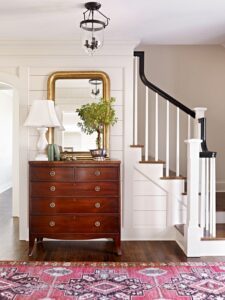 Red Turkish rug in traditional entryway with staircase