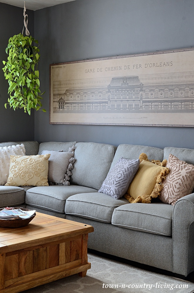 Dark gray living room with sectional sofa and large architectural print of Paris train station
