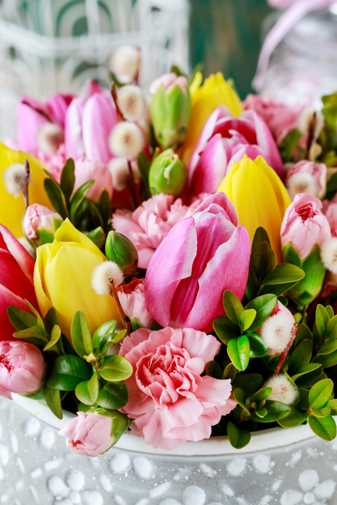 Spring flower arrangement with tulips, carnations, pussy willows, and boxwood