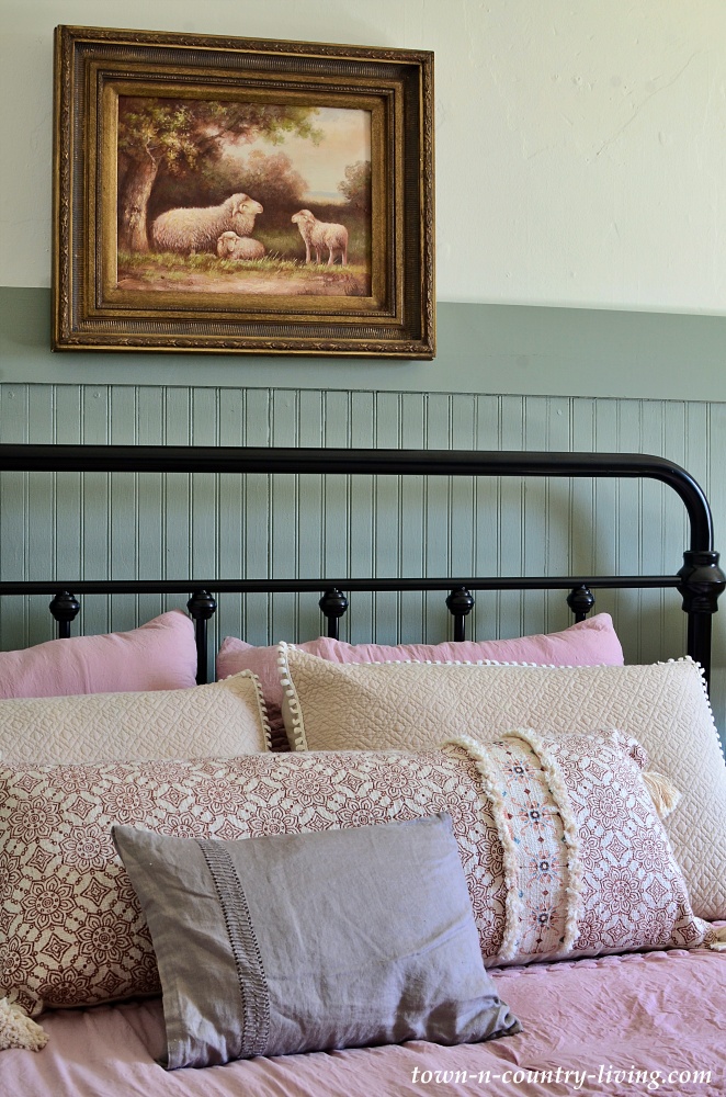 Farmhouse bedroom with black metal bed and soft rose bedding