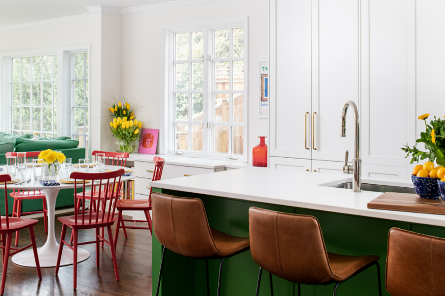 green and white kitchen with dining area with red chairs