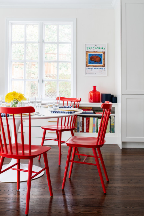Red Windsor chairs around a white modern dining table