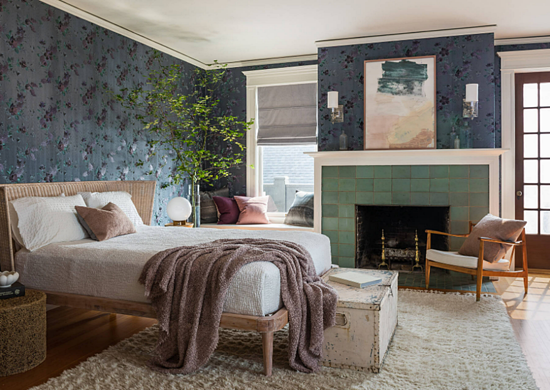 Eclectic bedroom in Tudor home with green-tiled fireplace