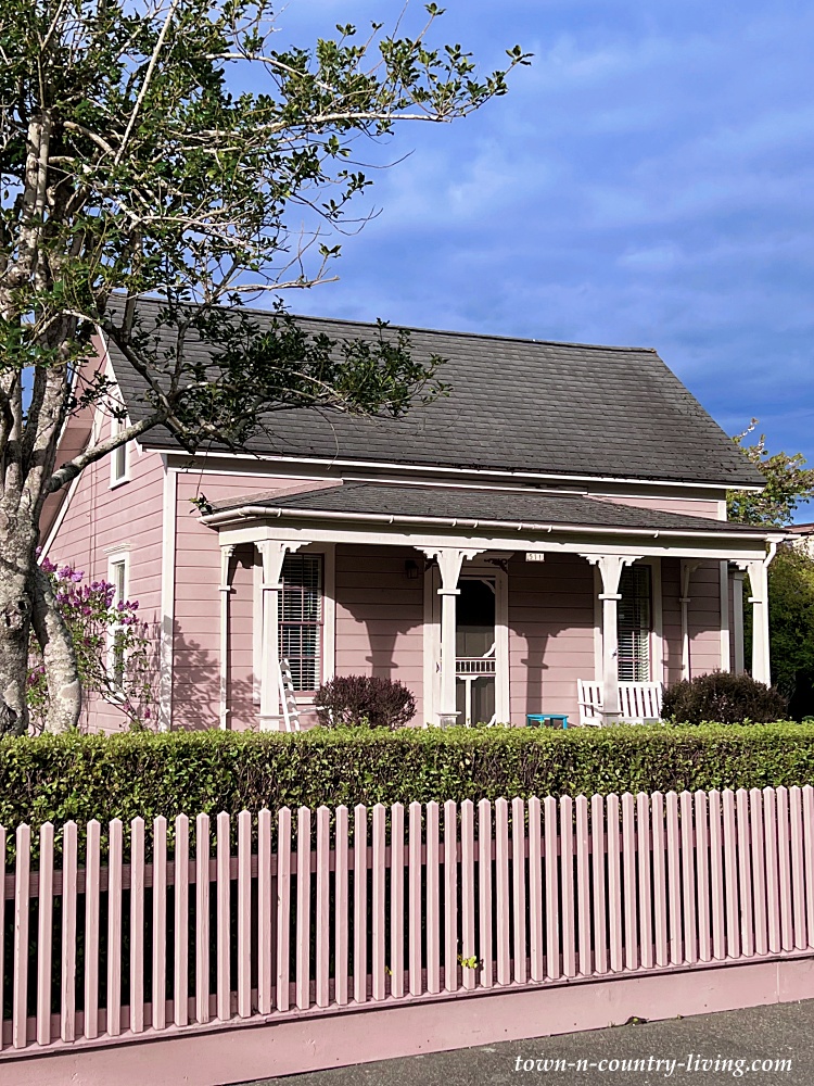 Pink cottage with full porch and picket fence