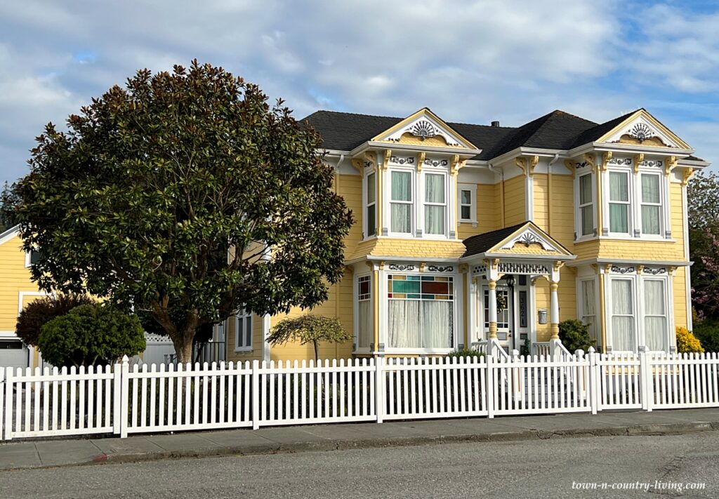 Yellow Victorian home with picket fence