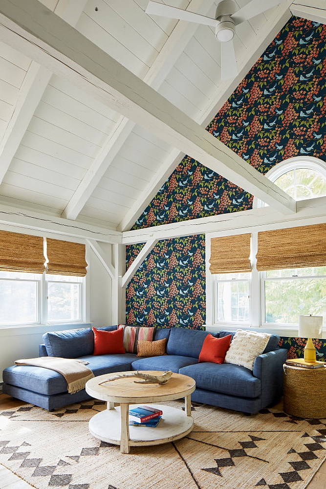 Colorful family room with vaulted ceiling and wallpapered wall