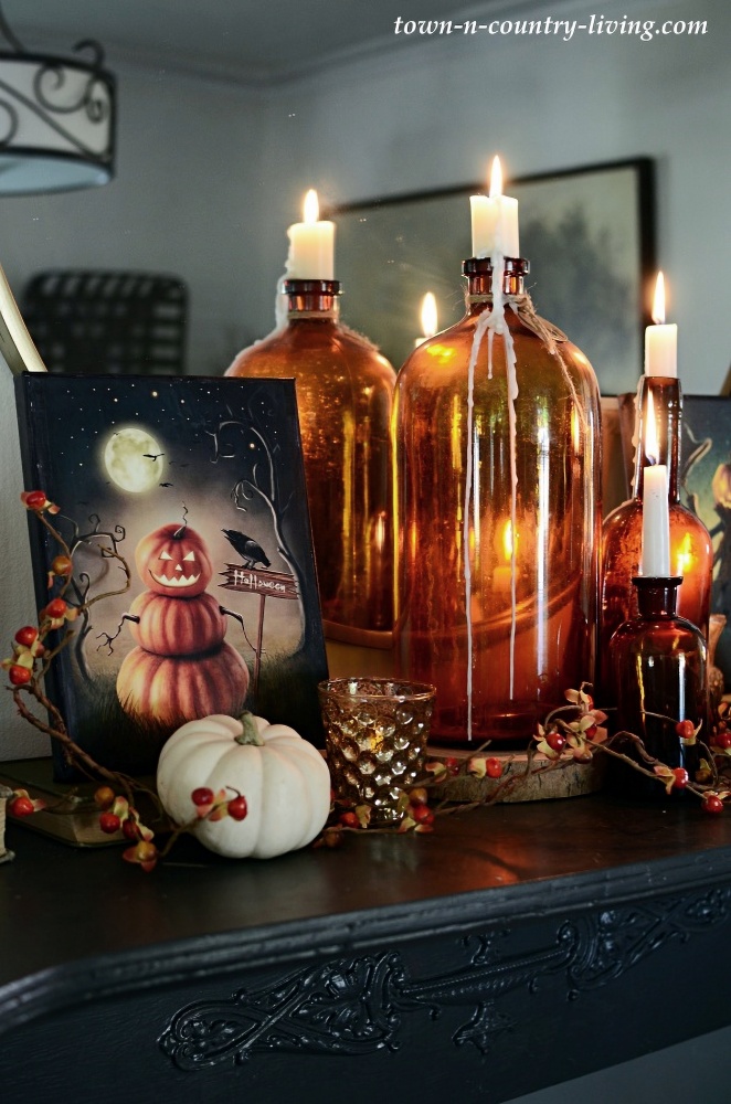 Vintage amber bottles as candle holders - Halloween mantel