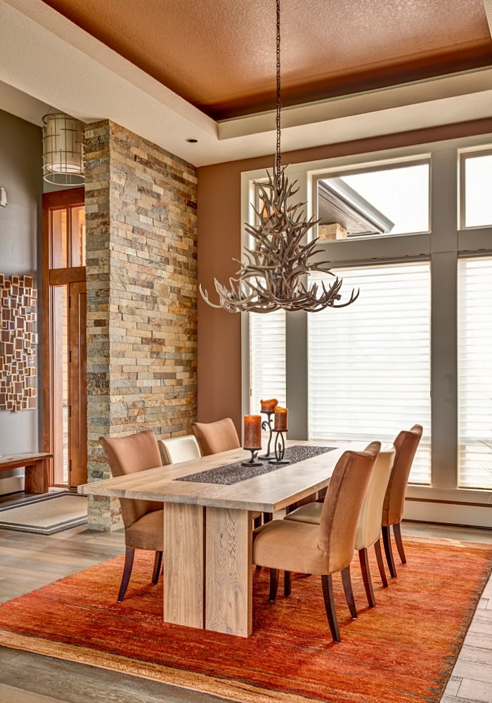 rustic dining with antler chandelier and stone wall