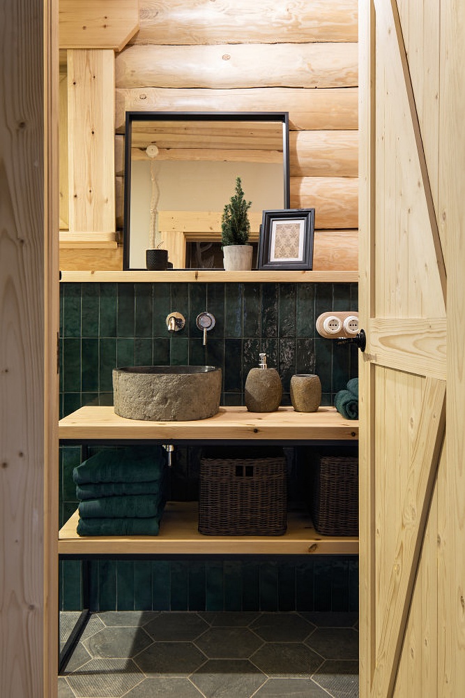 Powder room with dark green tile and light log walls