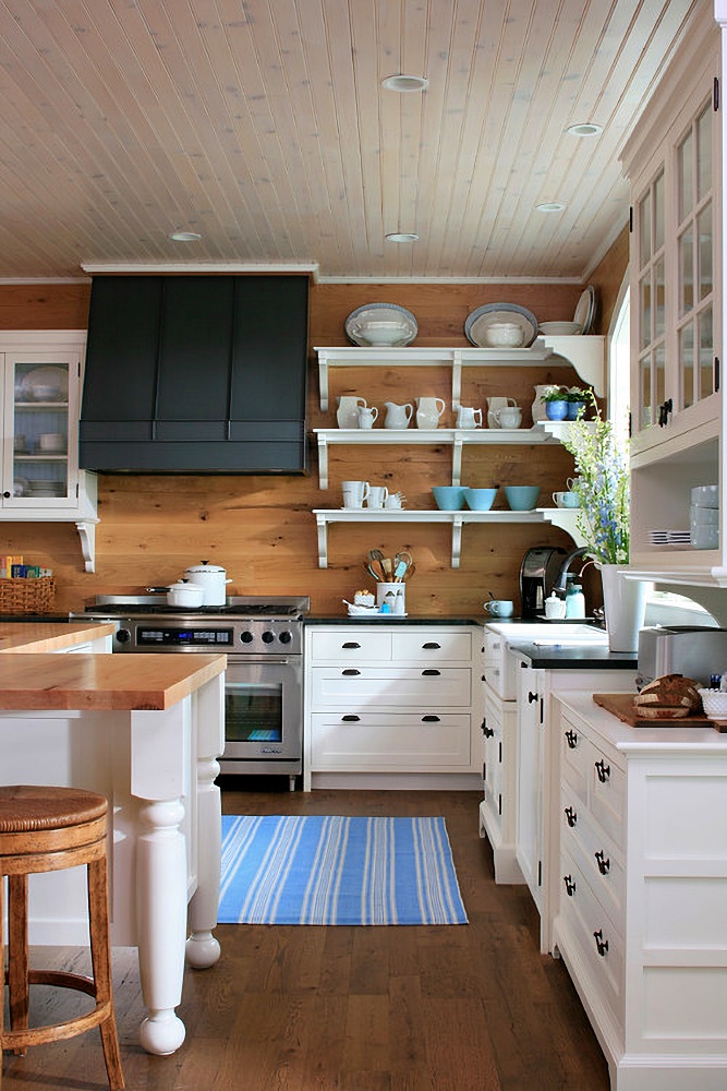 country kitchen with paneled walls and white cabinets