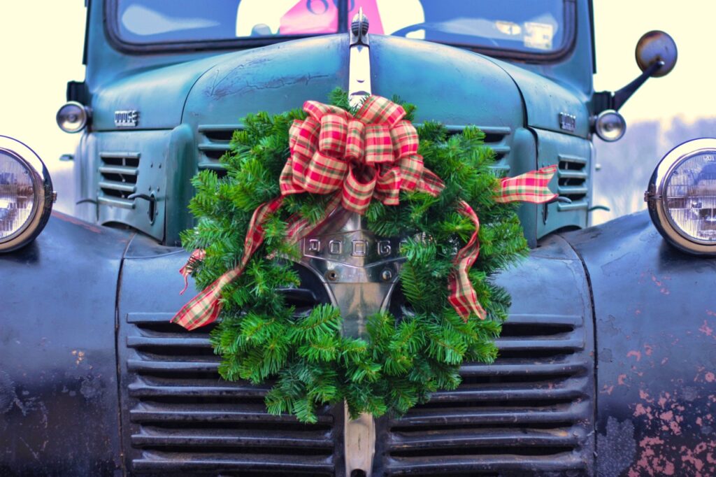 Vintage blue truck festooned with a Christmas wreath