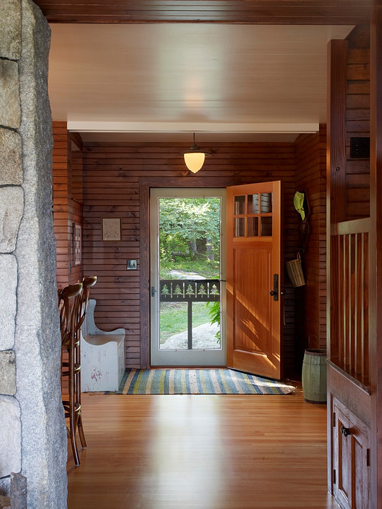 Maine bunk house entryway with horizontal wood paneling