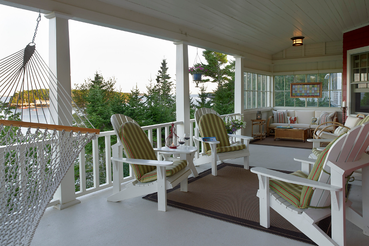 Expansive porch with Adirondack chairs and a view of the ocean