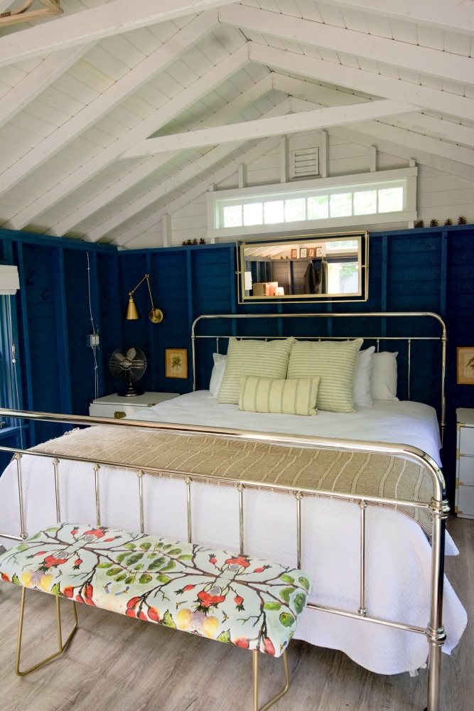 Beach cottage bedroom in navy and white with a metal bed